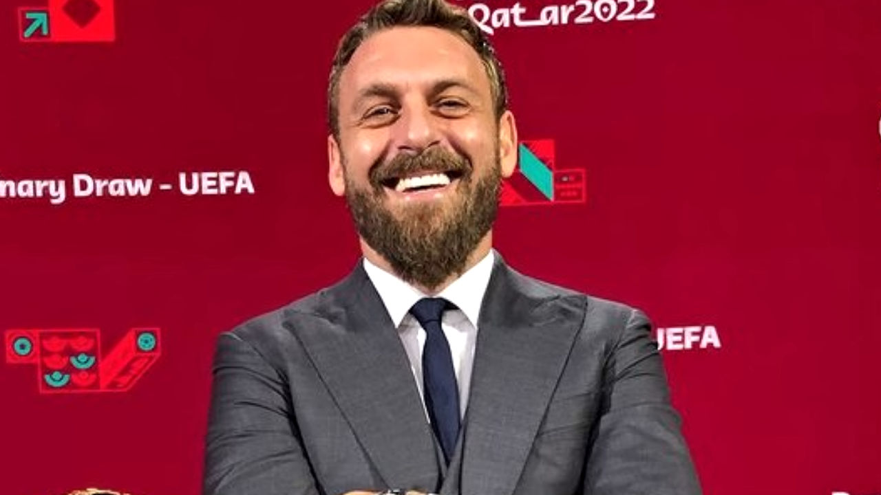 de rossi sorride sfondo rosso